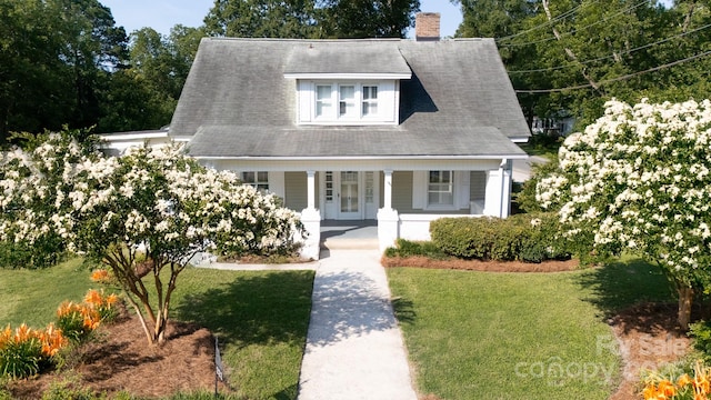 221 Kings Mountain St, Clover, SC 29710 - cape cod-style house featuring a front lawn, covered porch, a chimney, and french doors