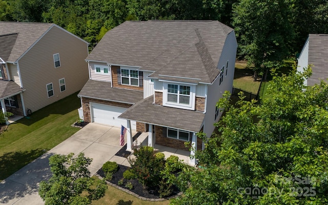 10666 Sapphire Trl, Davidson, NC 28036 - view of front of home featuring stone siding, concrete driveway, a garage, a front lawn, and a porch