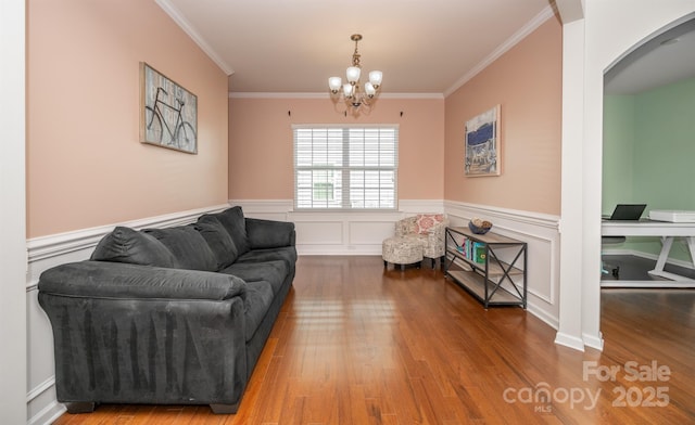 10666 Sapphire Trl, Davidson, NC 28036 - living area with wood finished floors, ornamental molding, a chandelier, arched walkways, and wainscoting
