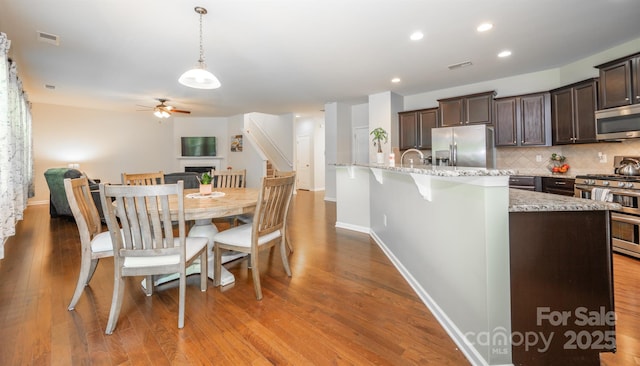 10666 Sapphire Trl, Davidson, NC 28036 - dining area featuring a ceiling fan, light wood finished floors, a fireplace, and recessed lighting