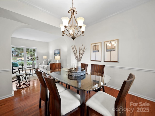 2808 Williams Station Rd, Matthews, NC 28105 - dining space featuring arched walkways, a chandelier, wood finished floors, and ornamental molding