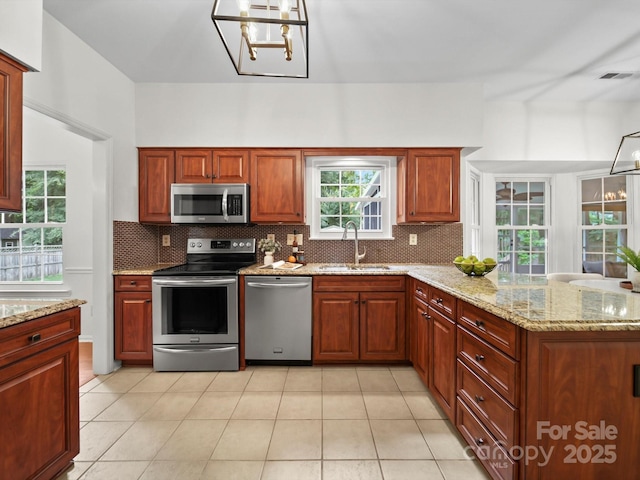 2808 Williams Station Rd, Matthews, NC 28105 - kitchen with appliances with stainless steel finishes, backsplash, a peninsula, light tile patterned flooring, and light stone counters