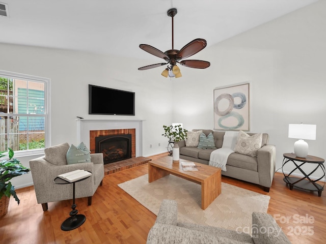 2808 Williams Station Rd, Matthews, NC 28105 - living area featuring light wood-type flooring, a fireplace, and a ceiling fan