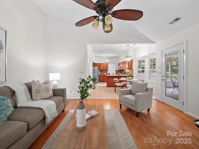 2808 Williams Station Rd, Matthews, NC 28105 - living room with vaulted ceiling, ceiling fan, light wood-style flooring, and a chandelier