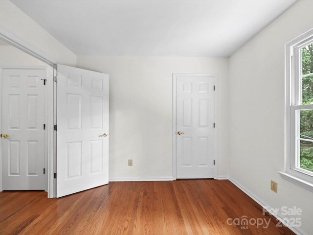 2808 Williams Station Rd, Matthews, NC 28105 - unfurnished bedroom featuring wood finished floors and multiple windows