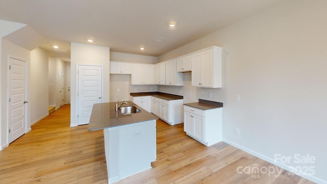 2511 Ruby Dixon Crossing Dr Unit 23, Gastonia, NC 28056 - kitchen featuring dark countertops, an island with sink, light wood-type flooring, recessed lighting, and white cabinetry