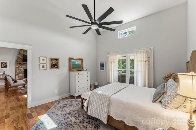5283 Mount Olive Church Rd, Morganton, NC 28655 - bedroom with a towering ceiling, wood finished floors, a stone fireplace, and ceiling fan