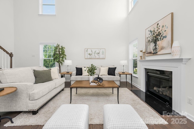 17203 Summers Walk Blvd, Davidson, NC 28036 - living area with a towering ceiling, dark wood finished floors, a glass covered fireplace, and stairs