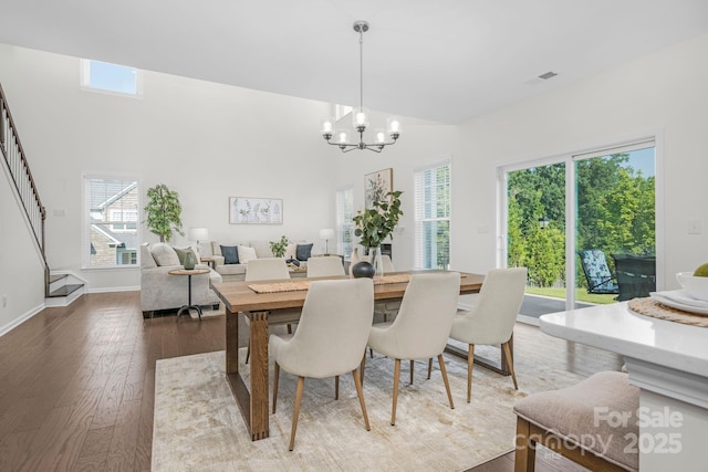 17203 Summers Walk Blvd, Davidson, NC 28036 - dining space with stairs, a chandelier, hardwood / wood-style floors, and a high ceiling