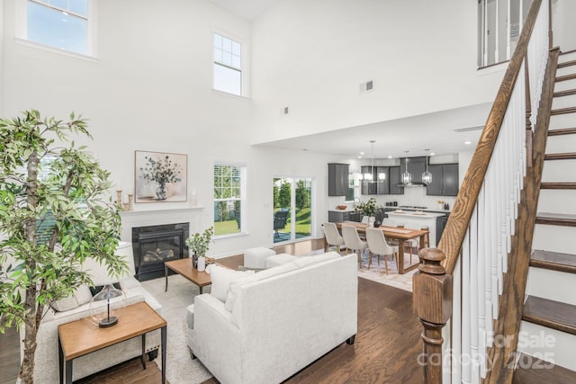 17203 Summers Walk Blvd, Davidson, NC 28036 - living room with stairway, a glass covered fireplace, dark wood-type flooring, and a towering ceiling