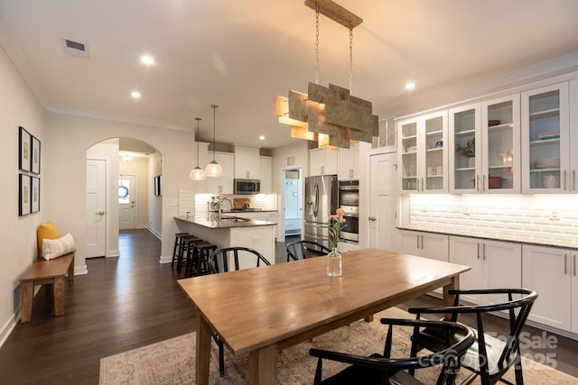 5907 Barrowlands Ct, Charlotte, NC 28210 - dining space with arched walkways, crown molding, recessed lighting, and dark wood-style flooring