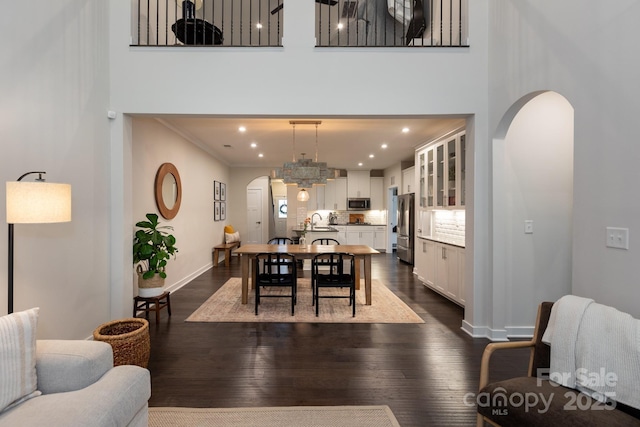 5907 Barrowlands Ct, Charlotte, NC 28210 - dining space featuring arched walkways, dark wood-style floors, recessed lighting, and crown molding