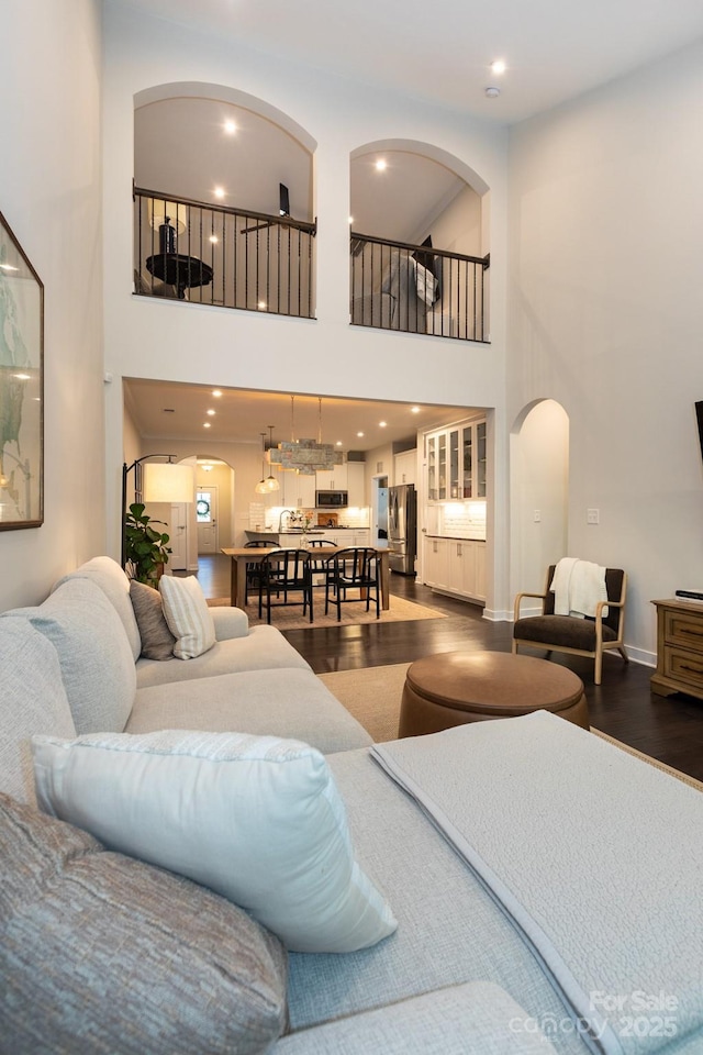 5907 Barrowlands Ct, Charlotte, NC 28210 - living room with arched walkways, a towering ceiling, dark wood-style flooring, and recessed lighting