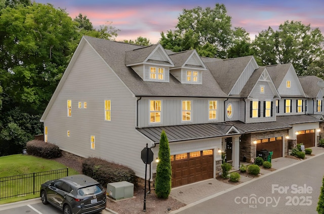 5907 Barrowlands Ct, Charlotte, NC 28210 - view of front facade featuring a standing seam roof, an attached garage, a shingled roof, a metal roof, and driveway