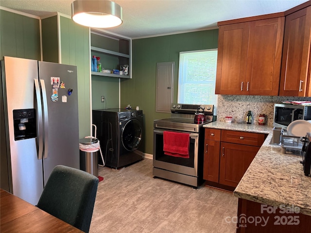 703 Stage St NW, Lenoir, NC 28645 - kitchen with appliances with stainless steel finishes, washer / dryer, ornamental molding, light wood-style flooring, and brown cabinets