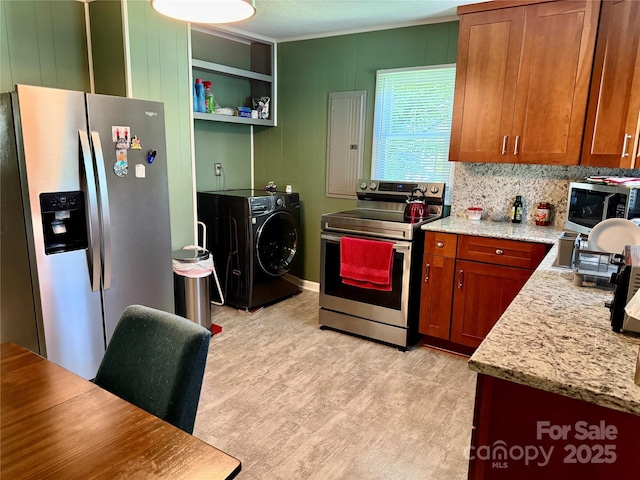 703 Stage St NW, Lenoir, NC 28645 - kitchen featuring appliances with stainless steel finishes, washer / dryer, light wood-type flooring, brown cabinets, and ornamental molding