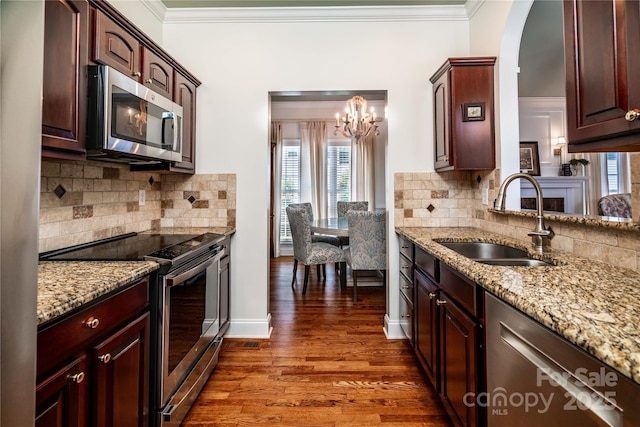 2218 Wednesbury Ct, Kannapolis, NC 28083 - kitchen featuring appliances with stainless steel finishes, a chandelier, healthy amount of natural light, crown molding, and dark wood-type flooring