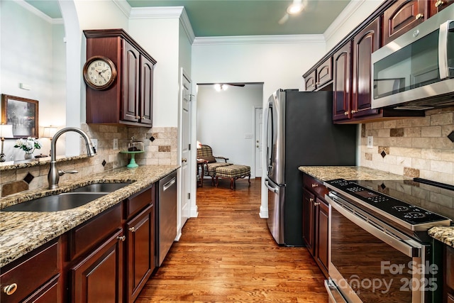 2218 Wednesbury Ct, Kannapolis, NC 28083 - kitchen featuring stainless steel appliances, backsplash, ornamental molding, light stone counters, and light wood-style floors