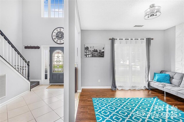 9910 Sandman Ln, Charlotte, NC 28216 - entryway with stairs, a textured ceiling, and a towering ceiling