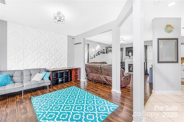 9910 Sandman Ln, Charlotte, NC 28216 - living room featuring wood finished floors, a fireplace, and an accent wall