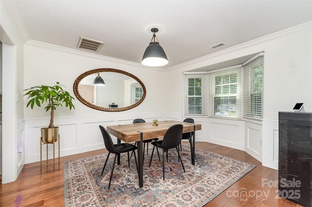 3106 Windstream Ct, Charlotte, NC 28210 - dining space featuring wood finished floors, crown molding, a wainscoted wall, and a decorative wall