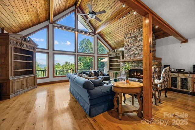 266 Lost Mine Trl Unit 602, Brevard, NC 28712 - living area featuring hardwood / wood-style flooring, high vaulted ceiling, a ceiling fan, a stone fireplace, and a wood ceiling with exposed beams