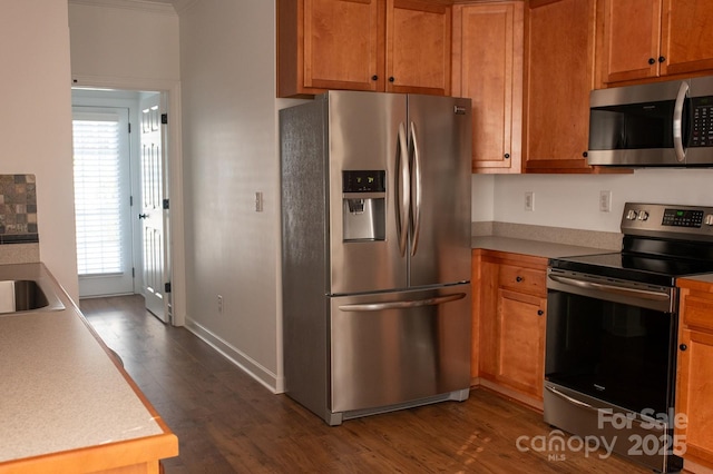 4500 Sages Ave, Indian Trail, NC 28079 - kitchen featuring appliances with stainless steel finishes, dark wood finished floors, light countertops, and brown cabinetry