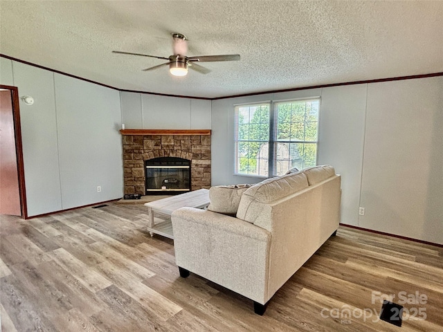 2268 Arrowwood Dr, Hickory, NC 28601 - living room with crown molding, ceiling fan, a textured ceiling, wood finished floors, and a fireplace