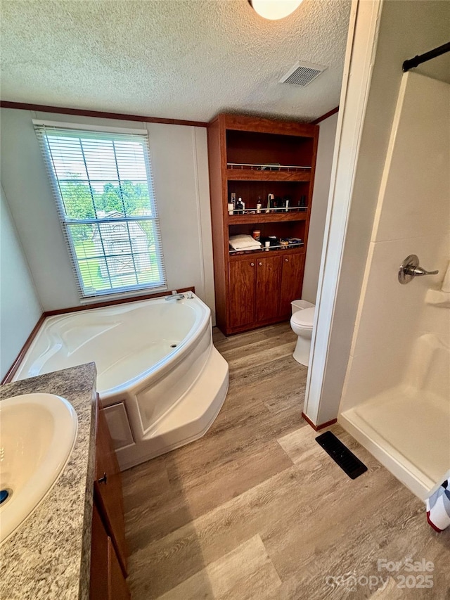 2268 Arrowwood Dr, Hickory, NC 28601 - full bathroom featuring wood finished floors, a stall shower, vanity, a textured ceiling, and a bath