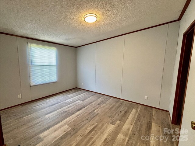 2268 Arrowwood Dr, Hickory, NC 28601 - spare room featuring ornamental molding, a decorative wall, wood finished floors, and a textured ceiling