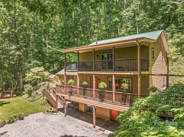 747 Bear Cove Cir, Bryson City, NC 28713 - view of front of property featuring a balcony, a metal roof, a forest view, a patio, and a front lawn