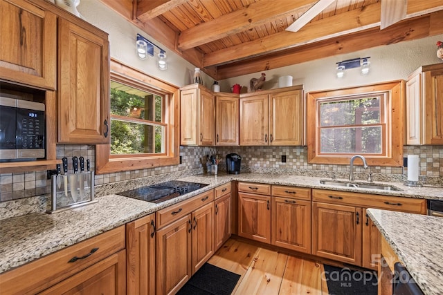 747 Bear Cove Cir, Bryson City, NC 28713 - kitchen with black electric cooktop, a wood ceiling with exposed beams, light wood finished floors, stainless steel microwave, and backsplash