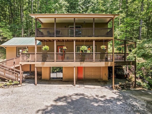 747 Bear Cove Cir, Bryson City, NC 28713 - rustic home with gravel driveway, a balcony, a garage, and a wooded view