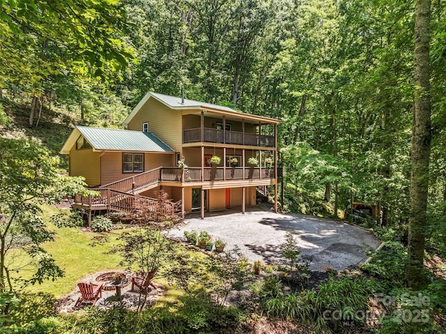 747 Bear Cove Cir, Bryson City, NC 28713 - back of property featuring an outdoor fire pit, a forest view, a balcony, a metal roof, and stairway
