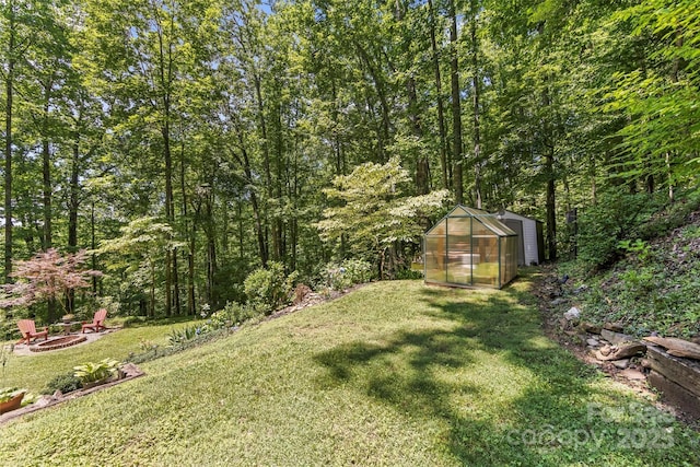 747 Bear Cove Cir, Bryson City, NC 28713 - view of grassy yard with a fire pit, an exterior structure, an outdoor structure, and a view of trees