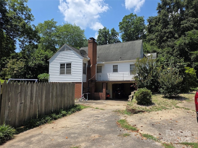 7335 US Highway 52, Salisbury, NC 28146 - view of front of house featuring driveway, stairway, a chimney, brick siding, and a wooden deck
