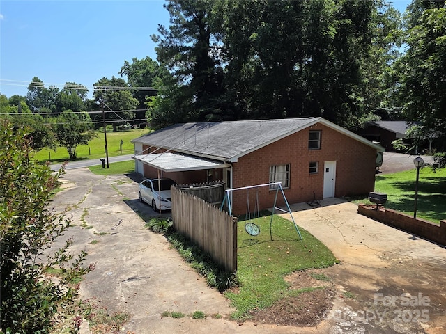 7335 US Highway 52, Salisbury, NC 28146 - view of property exterior with concrete driveway, brick siding, a playground, and a lawn