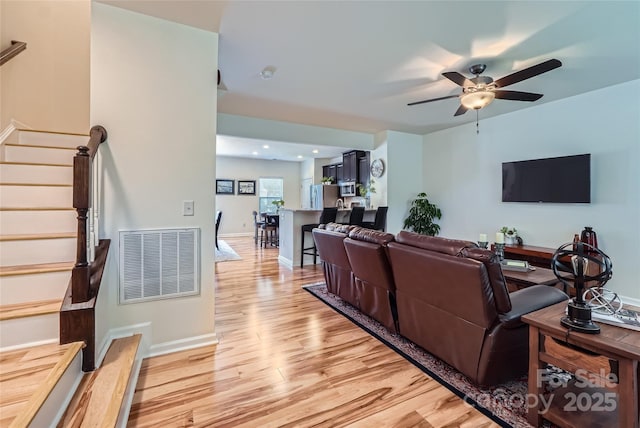 1727 Evergreen Dr, Charlotte, NC 28208 - living area featuring stairway, light wood-type flooring, and ceiling fan