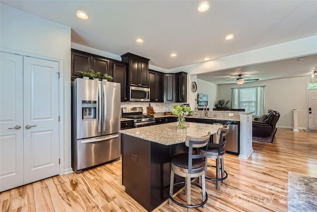 1727 Evergreen Dr, Charlotte, NC 28208 - kitchen featuring stainless steel appliances, open floor plan, a peninsula, a kitchen bar, and light wood finished floors