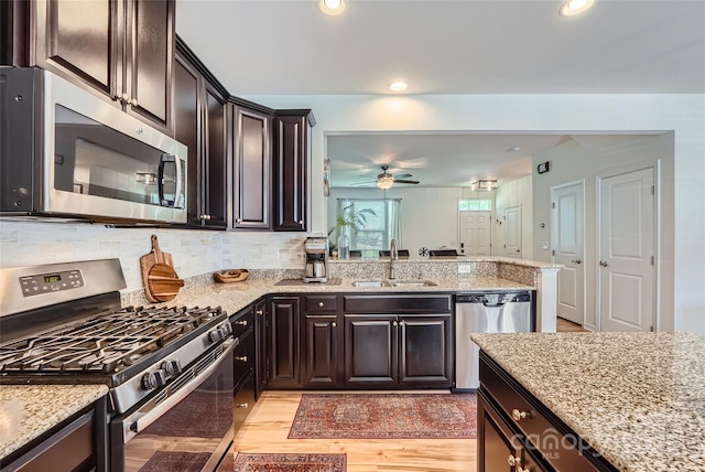 1727 Evergreen Dr, Charlotte, NC 28208 - kitchen with stainless steel appliances, a ceiling fan, recessed lighting, light stone countertops, and light wood-style floors
