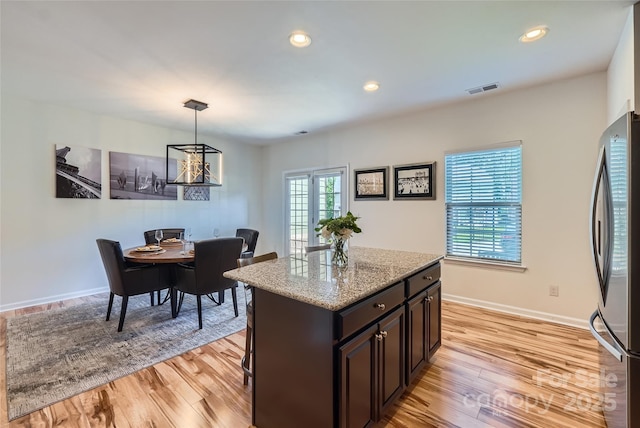 1727 Evergreen Dr, Charlotte, NC 28208 - kitchen featuring freestanding refrigerator, light wood-type flooring, light stone countertops, pendant lighting, and recessed lighting