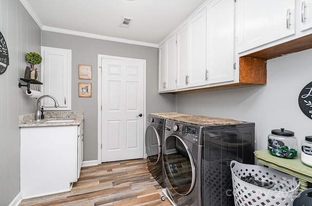 4710 Mooresville Rd, Salisbury, NC 28147 - laundry area with washer and dryer, light wood-type flooring, crown molding, and cabinet space