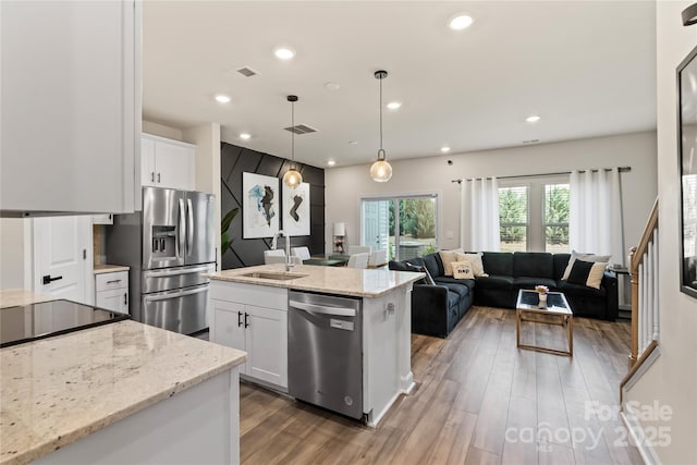 3740 Backwater St, Concord, NC 28027 - kitchen with stainless steel appliances, wood finished floors, recessed lighting, white cabinetry, and open floor plan
