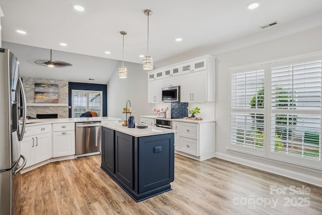 2607 Old Ashworth Ln NW, Concord, NC 28027 - kitchen with stainless steel appliances, light wood-style floors, light countertops, white cabinets, and a center island