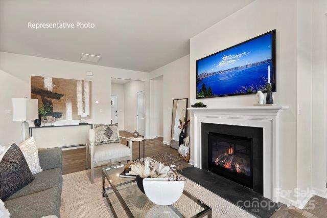 9235 Poquoson Dr, Gastonia, NC 28056 - living area with a glass covered fireplace and wood finished floors