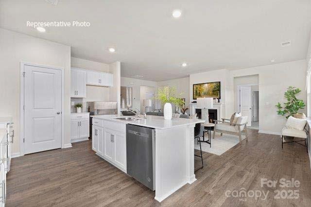 9235 Poquoson Dr, Gastonia, NC 28056 - kitchen with dishwasher, wood finished floors, white cabinetry, and recessed lighting