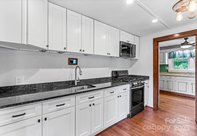 5215 Double Island Rd, Green Mountain, NC 28740 - kitchen with gas stove, stainless steel microwave, white cabinetry, recessed lighting, and wood finished floors