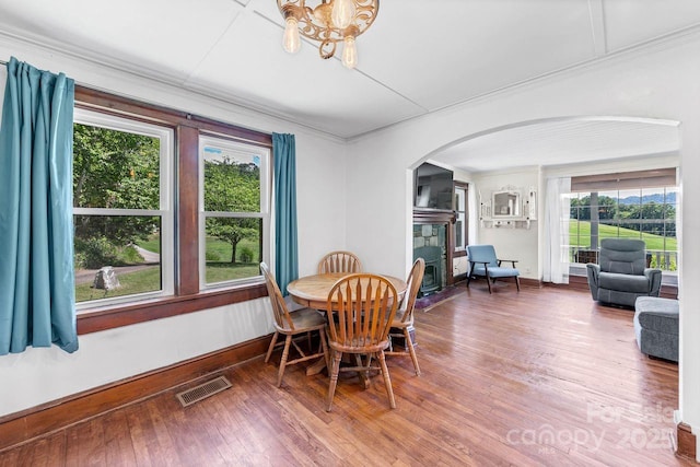 5215 Double Island Rd, Green Mountain, NC 28740 - dining area featuring arched walkways, a chandelier, wood finished floors, crown molding, and a fireplace