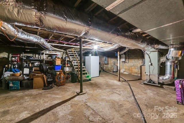 5215 Double Island Rd, Green Mountain, NC 28740 - unfinished below grade area featuring freestanding refrigerator, heating unit, and electric panel