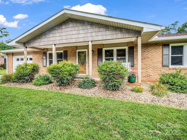 313 Resada Dr, Brevard, NC 28712 - view of front of house featuring a front lawn, a porch, brick siding, and a garage